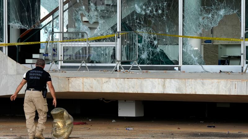 An agent walks past the head of a statue depicting the Greek goddess Themis, outside the...